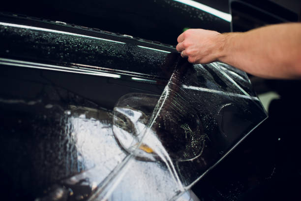 istock Worker hands installs car paint protection film wrap. 1144222954