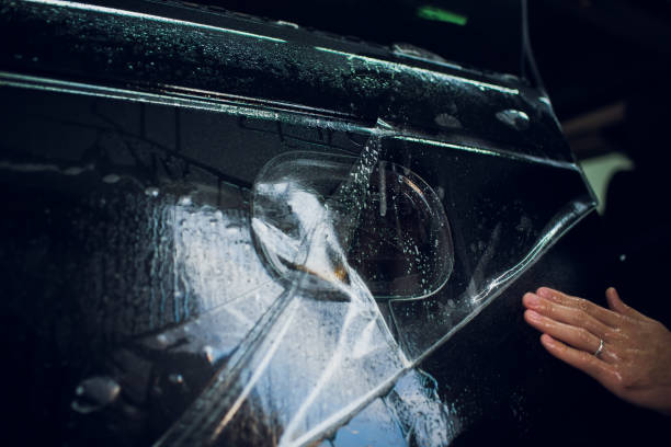 istock Worker hands installs car paint protection film wrap. 1144222965