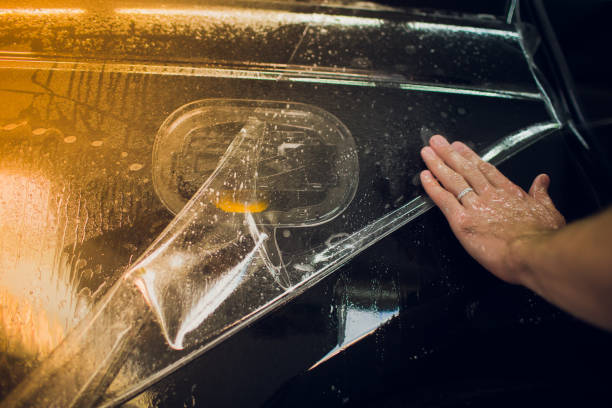 istock Worker hands installs car paint protection film wrap. 1144222971