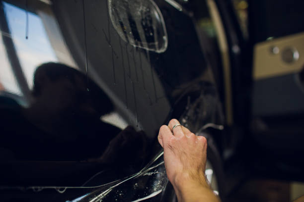 istock Worker hands installs car paint protection film wrap. 1144222988