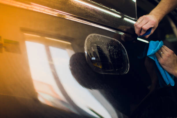 istock Worker hands installs car paint protection film wrap. 1144222994