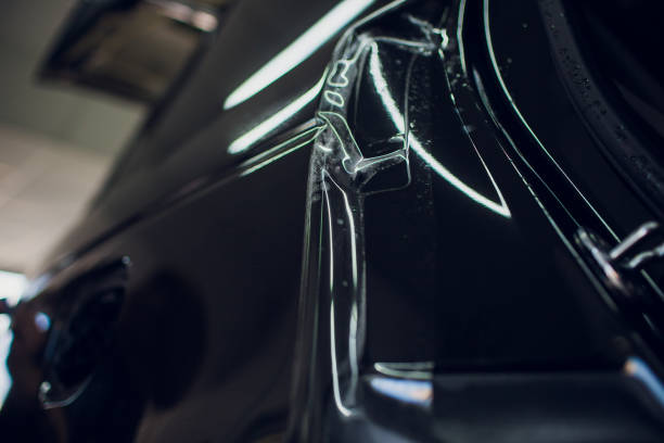istock Worker hands installs car paint protection film wrap. 1144222997