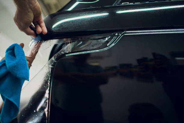 istock Worker hands installs car paint protection film wrap. 1144223003