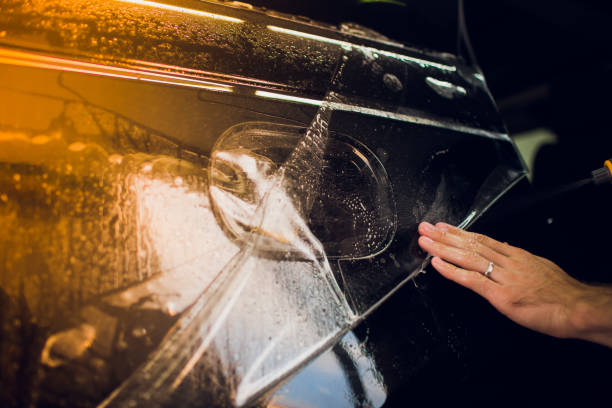 istock Worker hands installs car paint protection film wrap. 1144223022