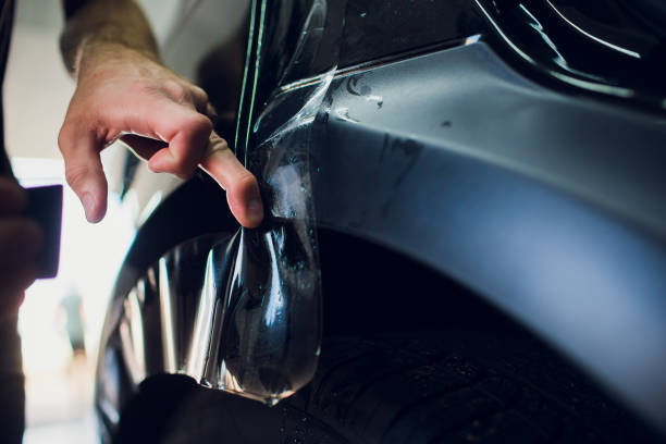 istock Worker hands installs car paint protection film wrap. 1144224221