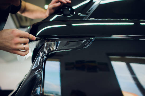 istock Worker hands installs car paint protection film wrap. 1144224227