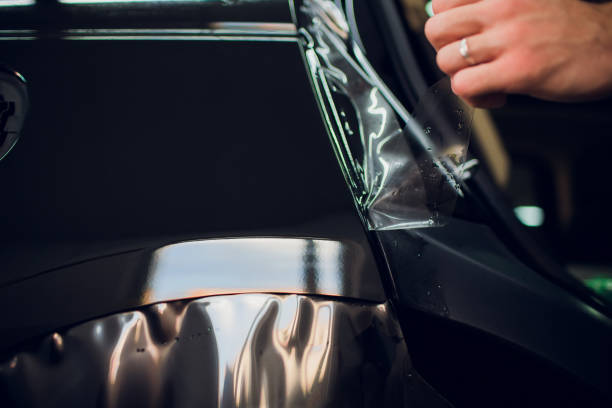 istock Worker hands installs car paint protection film wrap. 1144224255