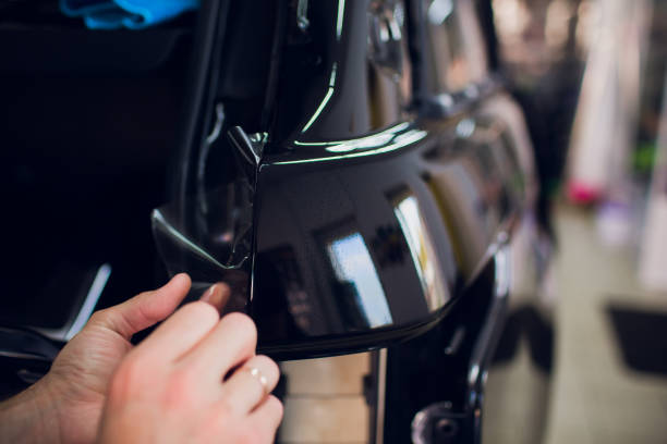 istock Worker hands installs car paint protection film wrap. 1144224257