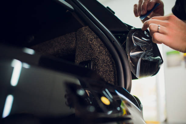 istock Worker hands installs car paint protection film wrap. 1144224270