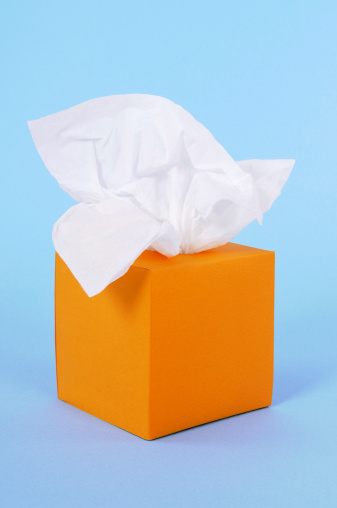 Tissues in orange box on a blue background.  Alternative tissue box isolated on white shown below: