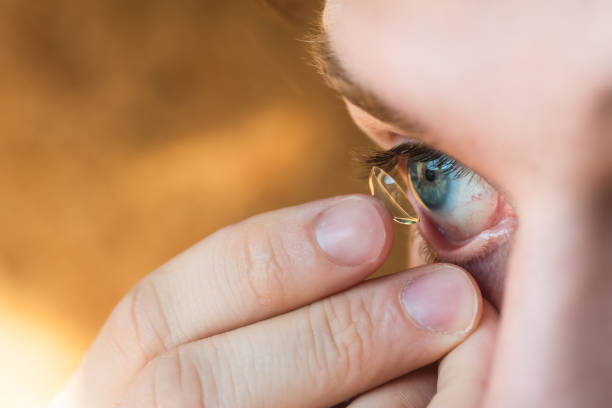 istock Mid adult man inserting a contact lens in eye 1144224949