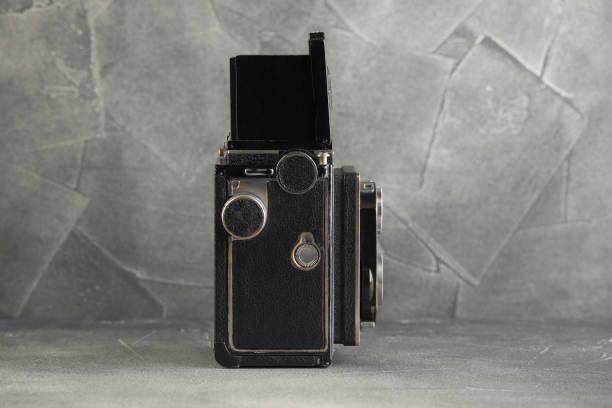 istock Old medium-format TLR Film camera on grey cement wall background. 1144224981