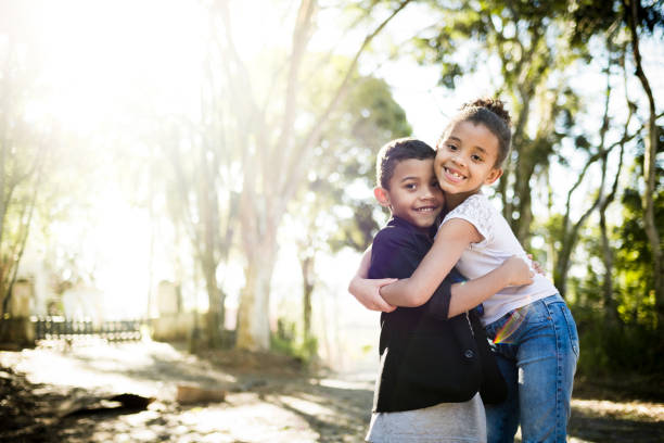 zwei kinder umarmen sich - familie mit zwei kindern stock-fotos und bilder