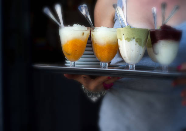 Salina, Sicily: Woman with Trayful of Granita Salina, Sicily, Italy: A woman carrying a tray crowded with goblets of granita, a Sicilian specialty. salina sicily stock pictures, royalty-free photos & images