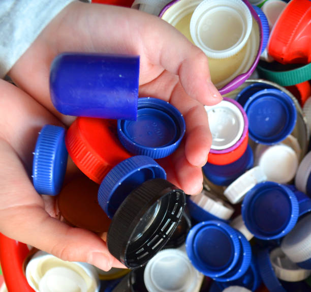 istock Boy hands collecting recycled plastic bottle caps 1144234565