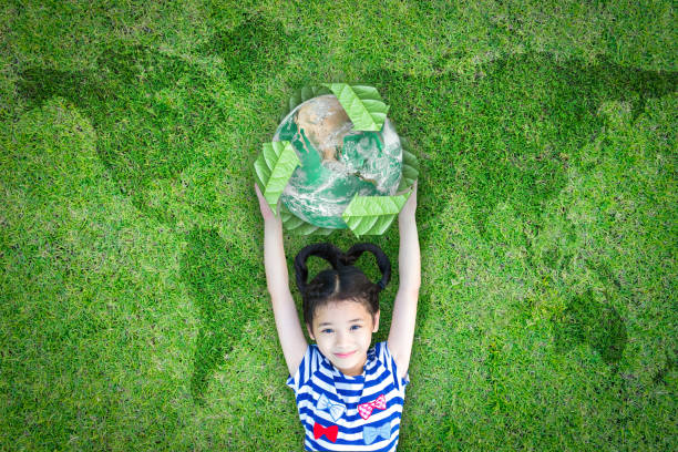 zrównoważone środowisko świata i csr z ludźmi koncepcji kampanii z dziewczyną dziecko podnoszenie ziemi na zielonym trawniku: element obrazu umeblowane przez nasa - environment child earth green zdjęcia i obrazy z banku zdjęć