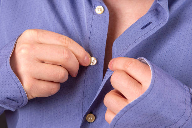 istock man fastens buttons on his shirt 1144240803