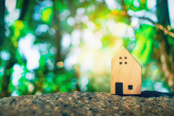 istock Closed up tiny home models on green nature bokeh sunlight background. 1144246865