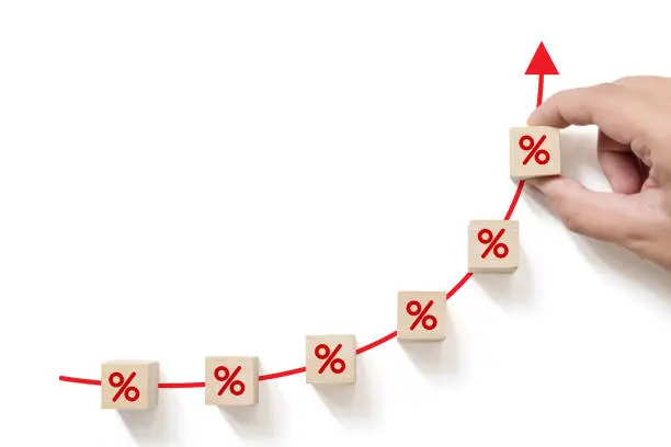 Photo of Interest rate financial and mortgage rates concept. Hand putting wood cube block increasing with icon percentage symbol upward direction