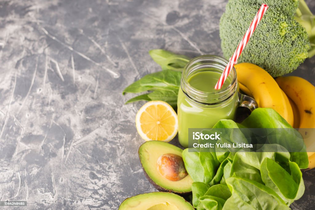 Green smoothie in moody dark background Green smoothie, greens, vegetable and fruits on moody background. Healthy eating, diet and vegetarian concept. Horizontal shot. Copy space for your text. Antioxidant Stock Photo