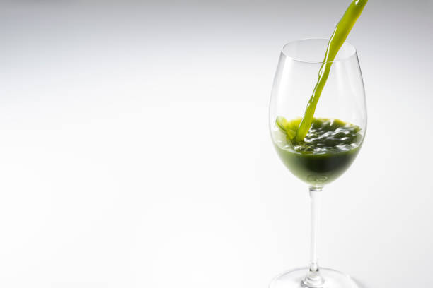 A simple concept shot of a wine glass with a healthy green vegetable water drink instead of wine.