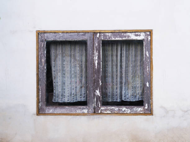 Close up vintage wooden window with old curtain on grunge concrete background.