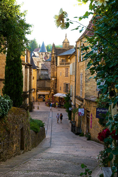 The medieval town of Sarlat-la-Caneda, France. Sarlat-la-Caneda,France-06 12 2014:People walking in the street of the old medieval town with impeccably restored stone buildings of Sarlat-la-Caneda or simply Sarlat, in the Dordogne department in southwestern France. sarlat la caneda stock pictures, royalty-free photos & images