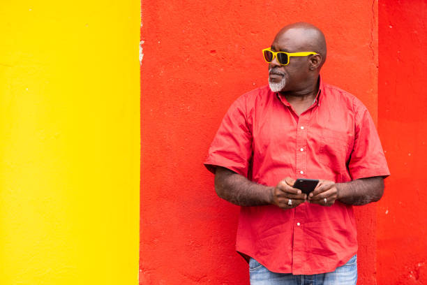 istock Mature afro man on colorful background using smartphone 1144260908