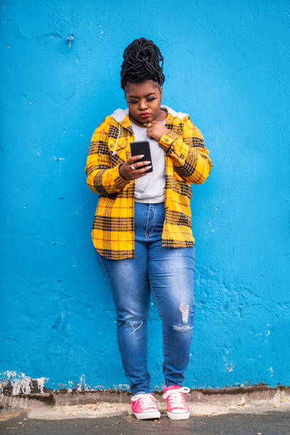 istock Afro woman using smart phone on a blue background 1144260913