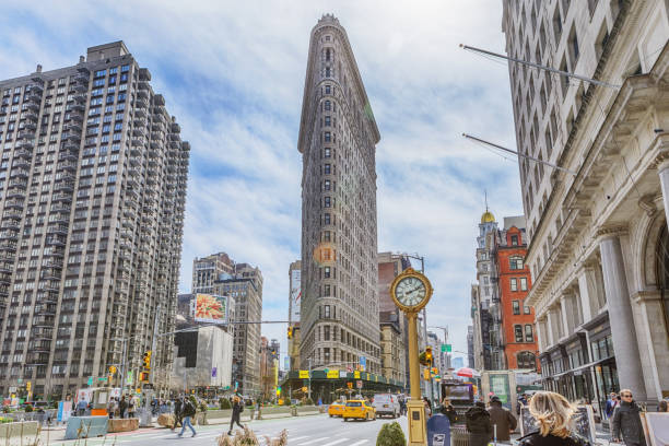 02 April 2019: Flatiron Building in Manhattan, New York, USA. Manhattan is world’s major commercial, financial and cultural center and the most densely populated of New York City’s 5 boroughs. The Flatiron Building, originally the Fuller Building, is a triangular 22-story, 285-foot tall steel-framed landmarked building located at 175 Fifth Avenue.