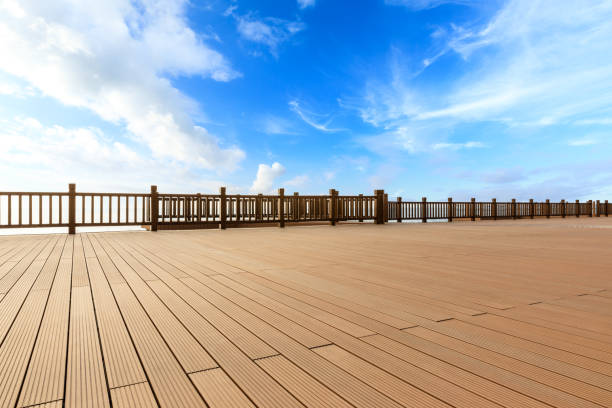 istock Lakeside wood floor platform and blue sky with white clouds 1144274628