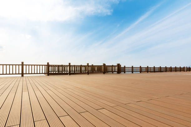 istock Lakeside wood floor platform and blue sky with white clouds 1144274636
