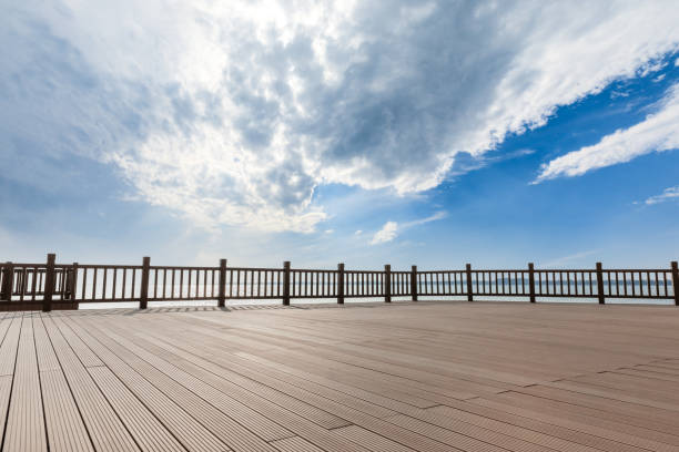istock Lakeside wood floor platform and blue sky with white clouds 1144275228