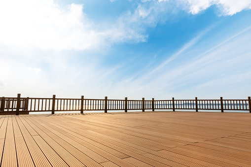 Lakeside wood floor platform and blue sky with white clouds landscape