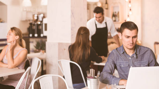 istock serious young man using laptop in modern cafe 1144275985