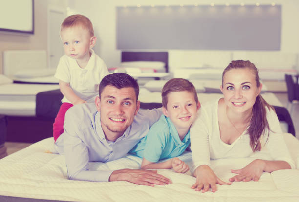 istock parents with two young sons testing mattress in store 1144276431