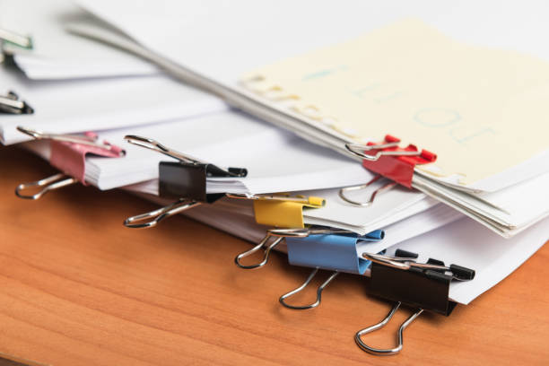 Paper business documents with color clips Paper business documents of unfinished stacked on office desk archive,in archive analyzing the market paper clip office supply stack heap stock pictures, royalty-free photos & images