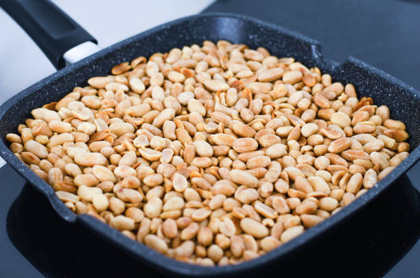 istock Frying on the stove in a black pan peanuts. 1144279409