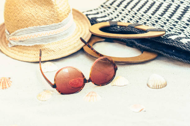 istock Straw hat, bag and sun glasses on a tropical beach 1144280867
