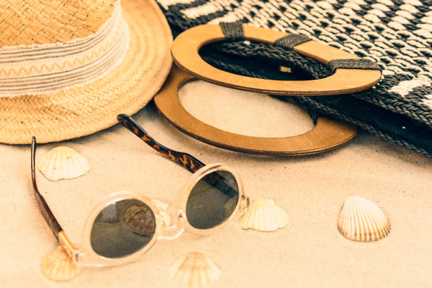 istock Straw hat, bag and sun glasses on a tropical beach 1144280948