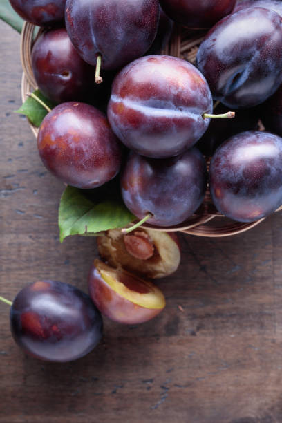 istock Ripe juicy plums on a wooden background. 1144281649