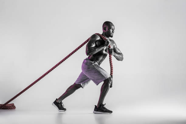 istock Young african-american bodybuilder training over grey background 1144281897