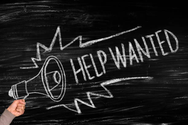istock Hand holding megaphone with Help Wanted announcement 1144282205