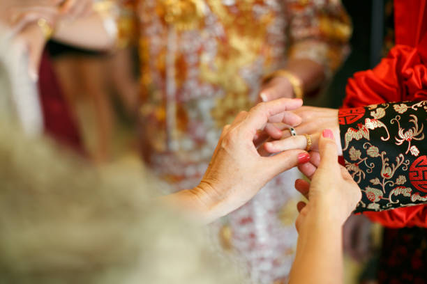 istock Elder putting on a ring to a Chinese wedding bridegroom 1144284555
