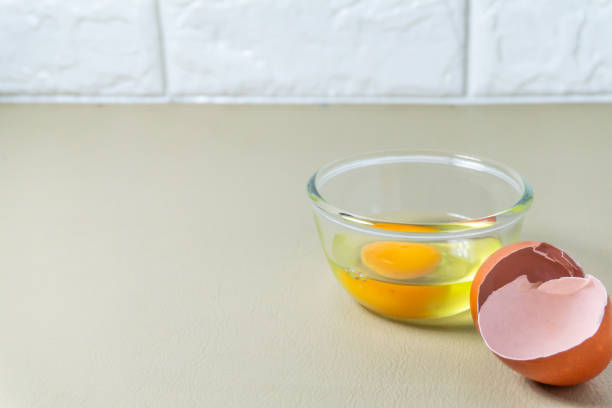 istock Cracked whole chicken eggs in a clear glass cup on the kitchen floor 1144284921