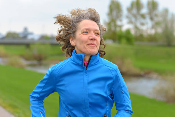 istock Happy fit middle-aged woman out jogging 1144285091