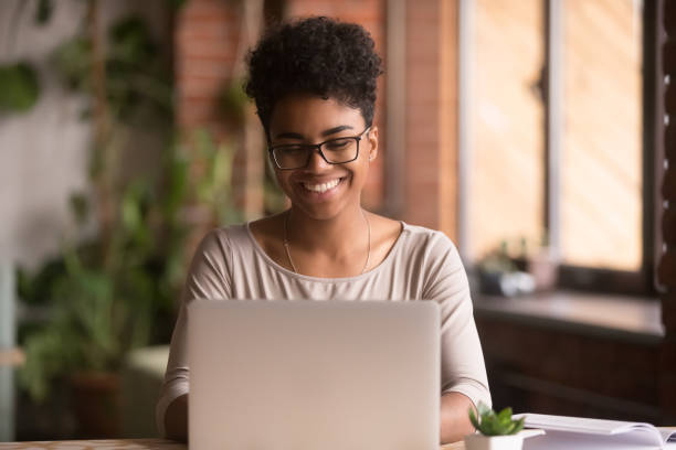 istock Happy mixed race woman student using laptop working studying indoor 1144287283