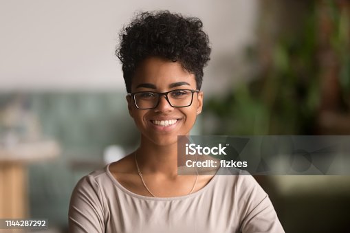 istock Headshot portrait of happy mixed race african girl wearing glasses 1144287292