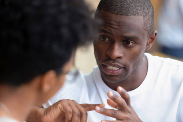 Focused african man having serious talk with woman at meeting Focused african american man looking speaking to woman having business talk negotiating explaining, serious black guy having conversation with girlfriend friend discussing important issues at meeting serious talk stock pictures, royalty-free photos & images