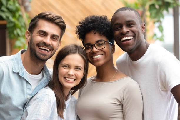 Happy multiracial friends group bonding looking at camera, portrait Happy multiracial friends group bonding looking at camera, young diverse people laughing having fun posing together, multi ethnic african and caucasian friendship reunion concept, head shot portrait colleagues outside stock pictures, royalty-free photos & images